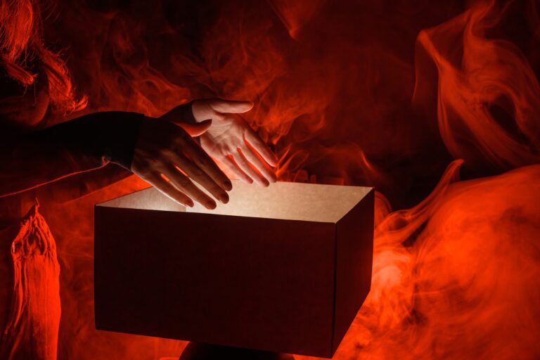 Man opens magic box with surprise on dark background, mystical box, surprise, halloween